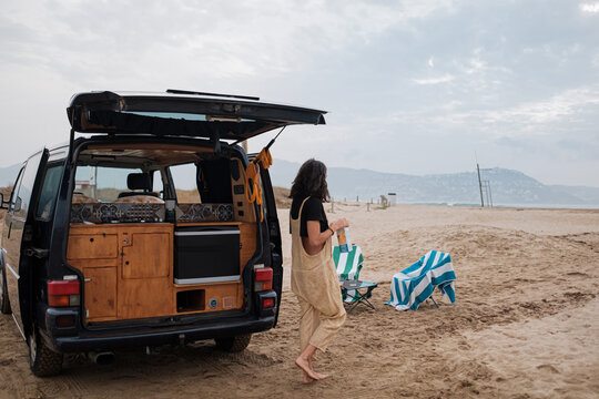 woman camping on the beach with camper