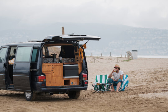 Man camping on beach with caravan