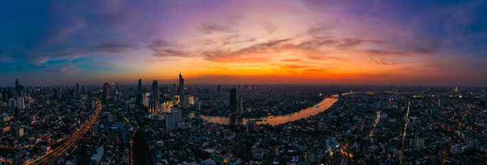 Aerial view of Bangkok skyline and skyscraper with light trails on Sirat Expy (toll road) center of the Chao Phraya River in Bangkok Thailand at sunset.