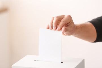 Voting young man near ballot box