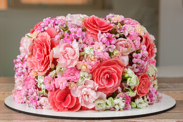 Vanilla cake closeup covered by edible Kalanchoe flowers.