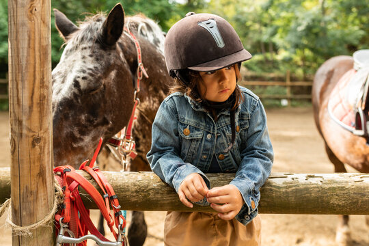 Girl in fenced stable