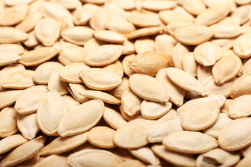 Natural pumpkin seeds as background, closeup