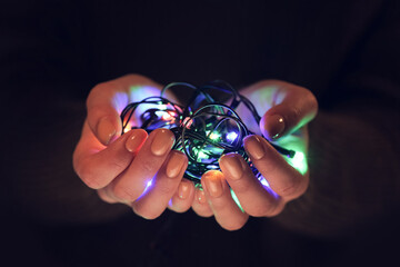 Woman holding Christmas glowing lights, closeup