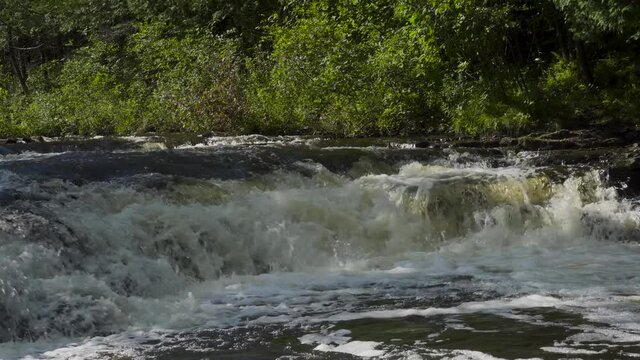River water rushing over the rocks; Ocqueoc Falls, rushing water over layers of rocks in Northwest Michigan after months of rain in late summer--late morning. 434