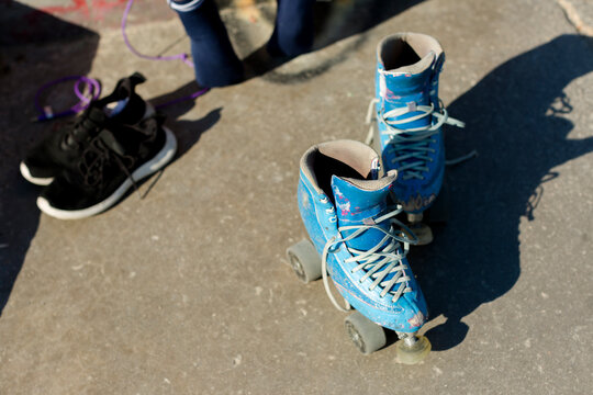 Old vintage blue roller skates on concrete ground