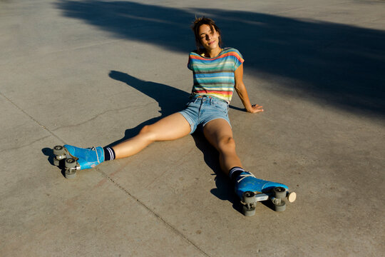 Roller skater woman in skate park resting in sunlight