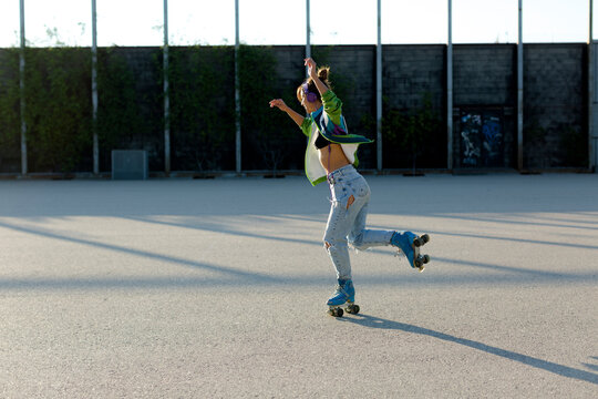 Roller-skater girl doing tricks in sunlight