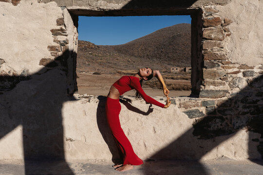 Dancer in a clique pose next to the hollow window