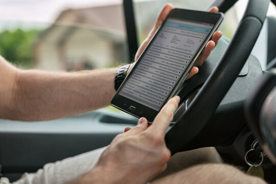 Shipping: Man Checks Delivery Route List On Tablet