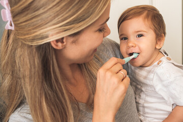 Mother Showing A Baby How To Brush Her Teeth