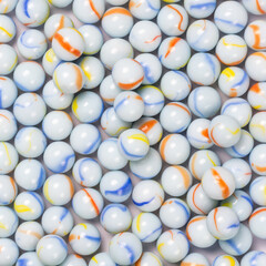blueish white crystal spheres, background texture of colorful marbles, wallpaper or backdrop for designing closeup taken from above
