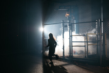 Young girl runs in an industrial area