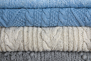 Stylish blue and grey sweaters as background