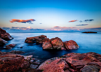 Sunset over rocks in the ocean in Canada