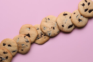 Tasty cookies with chocolate chips on pink background