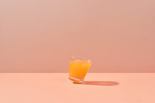 Glass of fresh orange juice on biege background