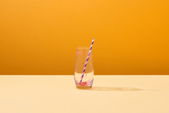 Empty glass of beetroot juice with a straw