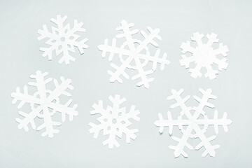 Fototapeta na wymiar Beautiful paper snowflakes on light background