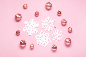 Beautiful paper snowflakes and Christmas balls on pink background