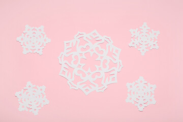 Beautiful paper snowflakes on pink background