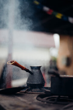 Turkish coffee being cooked in a metal cezve