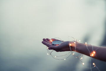 Young woman hold compass in hand at the sea shore. Selective focus. Shallow depth of field. 