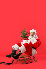 Sledding Santa Claus with Christmas tree on color background