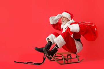 Sledding Santa Claus on color background