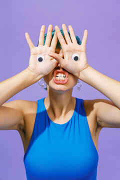 Young woman with toy eyes on hands