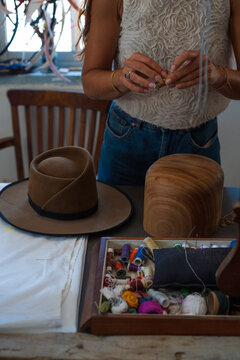 Designer in the process of shaping a hat with a block
