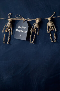 A note with tiny skeletons hanging with string 
