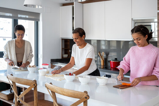 Woman and teenagers cooking lunch