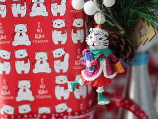 Christmas toy tiger with a bottle hanging on a spruce paw