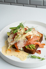 Very yummy and appetizing salmon sandwich on sweet brioche with hollandaise sauce, top view, menu photo
