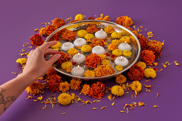 Woman putting flowers and candles on tray