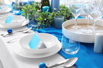 Dining table with beautiful setting for Christmas celebration and blank cards in room