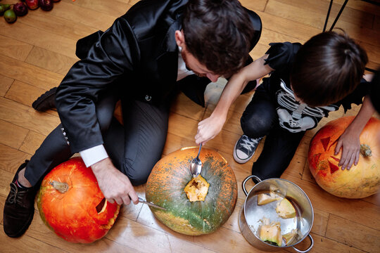 Little boy scooping seeds from pumpkins
