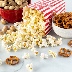 Close up of containers of peanuts, popcorn and pretzels ready for snacking.
