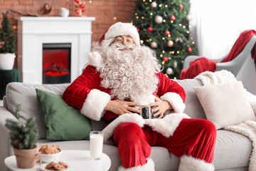 Happy Santa Claus sitting on sofa at home