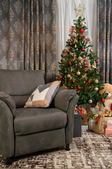 Living room decorated with a sofa for one person and Christmas tree and gift boxes and toys.