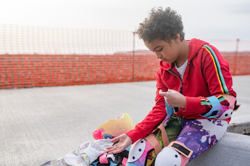 Girl focuses on putting on elbow pads