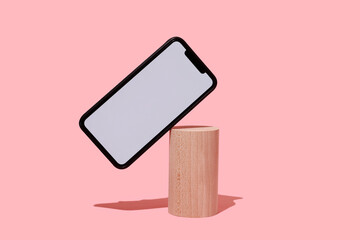 blank smartphone in balance on a cylinder