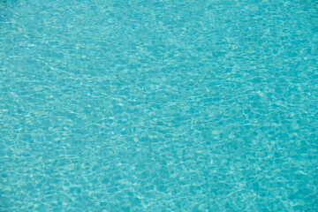 Ripple Water in swimming pool with sun reflection. Wavy water background.