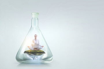 Business woman doing yoga in lotus pose inside glass bottle
