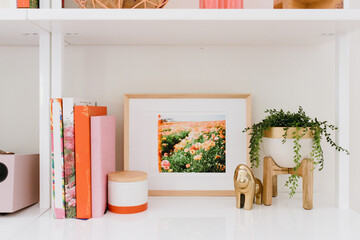 Styled white bookshelf with framed art