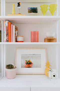 Colorful white bookshelf with art