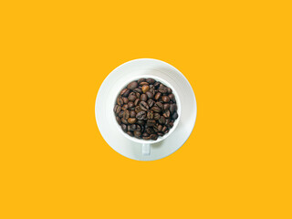 Dark brown coffee beans in white coffee cup and saucer in ther center picture.  orange background.