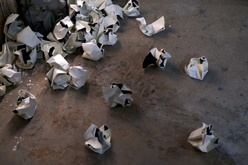Closeup of a wastebasket and paper balls in the corner