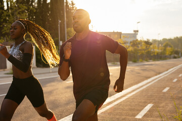 Fit black couple running in sunlight